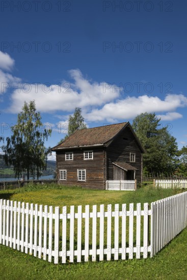 Old farmhouse surrounded by a white-painted fence, Maihaugen open-air museum with houses and