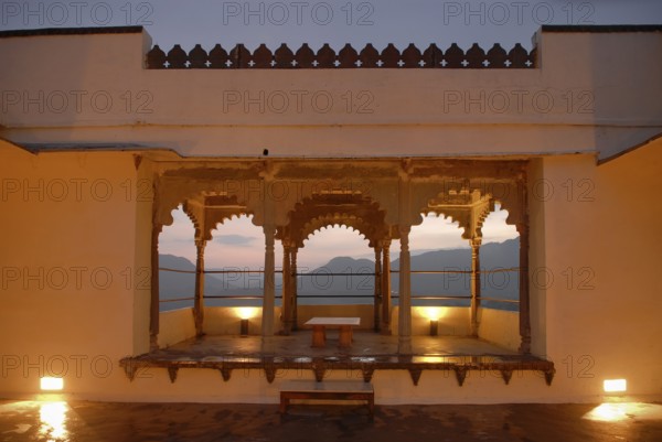 View through illuminated, traditional arched architecture of a slightly elevated terrace of