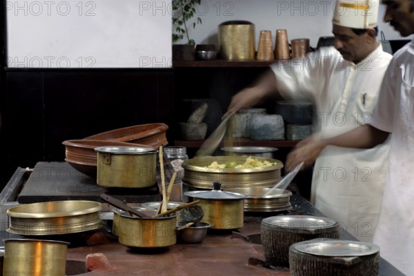 Chefs work in a traditional Tamil kitchen, copper pots and intensive cooking activity, Villa