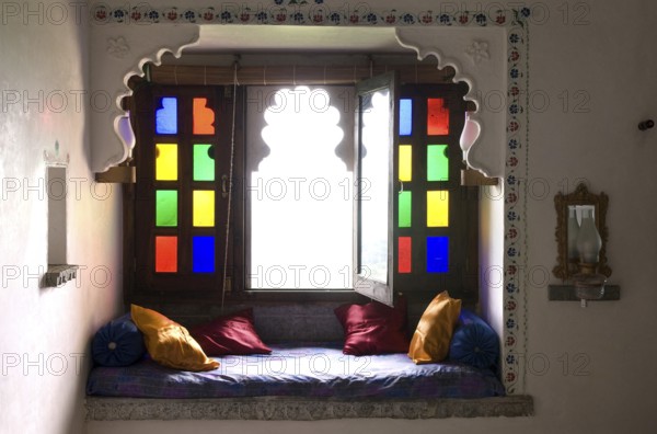 Cosy sitting area with colorful window and pillows, traditional style and cozy atmosphere,