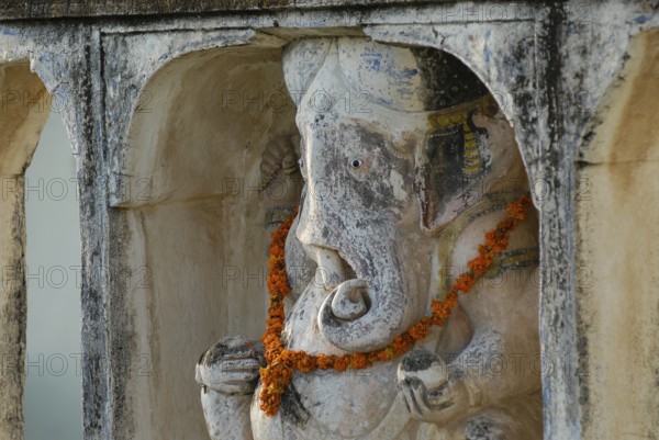 A Ganesha statue decorated with flower garland, Devigarh Palace Hotel, Delwara village near