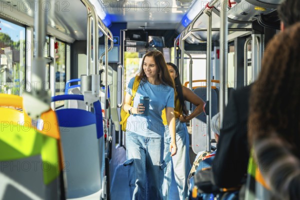 Young woman passenger holding a reusable coffee cup and backpack, walking through the aisle of a