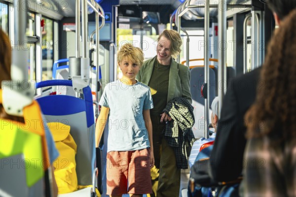 Mother and son traveling together inside a modern public transport bus, enjoying a casual family