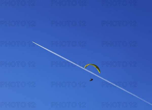 Paragliders with contrails in the blue sky, Osterhorn Group, Salzkammergut, Province of Salzburg,