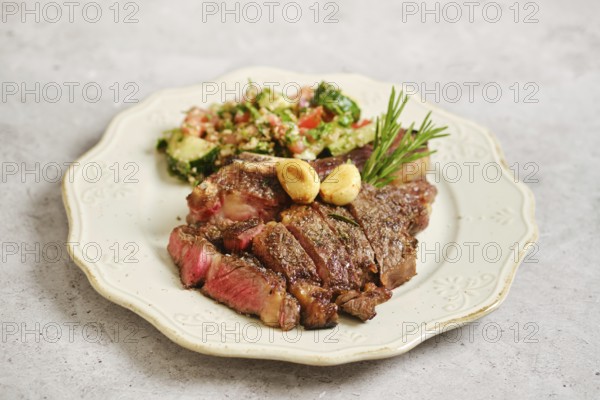 Juicy grilled steak on a vintage plate. Next to it, a vibrant tabbouleh salad features chopped