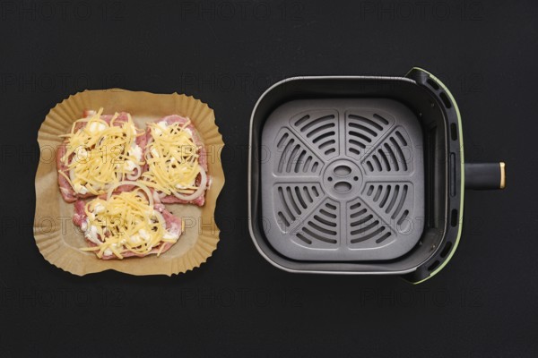 Three seasoned pork chops arranged on a parchment-lined tray, garnished with shredded cheese. Next