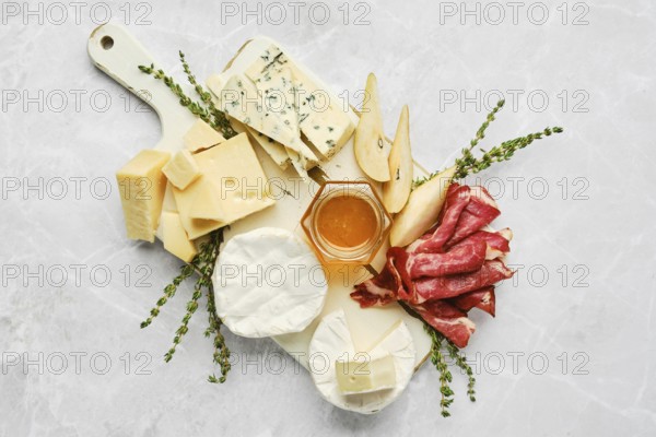 A beautifully arranged serving board features a variety of cheeses, cured meats, and fresh fruits.