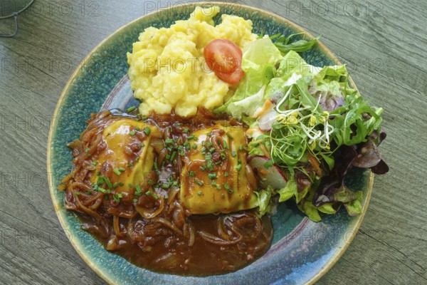 Swabian cuisine, ravioli with potato salad, gravy with onions, colorful salad, mixed salad side