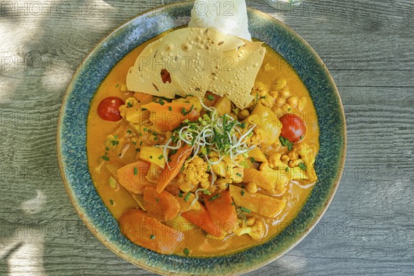 Asian cuisine, mixed vegetables, carrots, cauliflower, bamboo, cherry tomatoes, curry sauce,