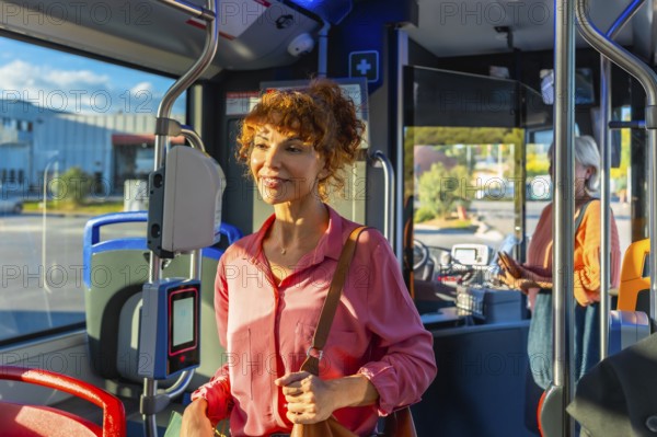 Smiling redhead woman validating a smart ticket on a modern city bus, preparing for her daily
