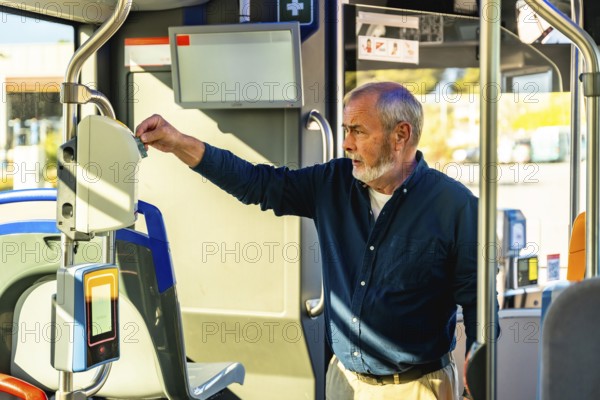 Senior man inserting his travel ticket into a modern validator device inside a public