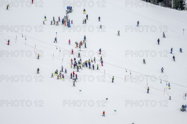 Ski lessons and many skiers on a ski slope with drag lift, view from above, Hochbrixen in winter,