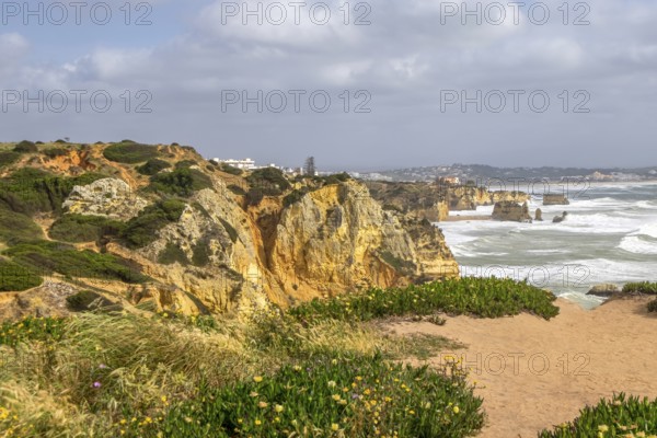 Cliff landscape on a seashore with cloudy sky and rough sea, Algarve, Portugal