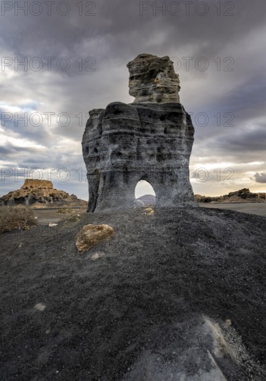 Eroded rock formations with rock tunnels, volcanic landscape with dramatic cloudy skies, Ciudad