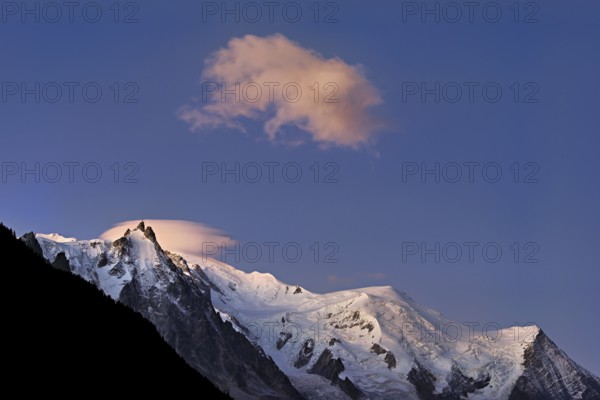 Aiguille du Midi snow-covered from left with sun-lit cloud over the summit, Mont-Blanc, Vallot Hut,