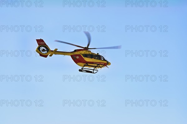 Helicopter flying against a blue sky, alpine rescue, mountain rescue, Chamonix, Haute-Savoie,