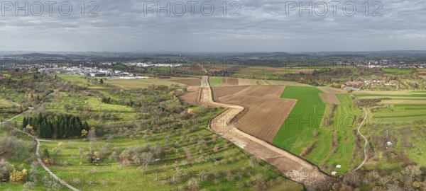 Panoramic picture of an extensive rural landscape under a grey sky, construction site, the South