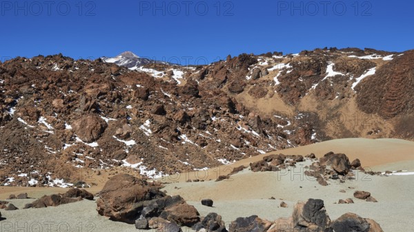 Barren volcanic landscape with rocks and snow trails under clear sky, UNESCO World Heritage Site,