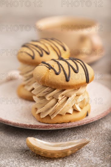 Caramel Cream Cakes on brown concrete background, cup of coffee, side view, close up, selective