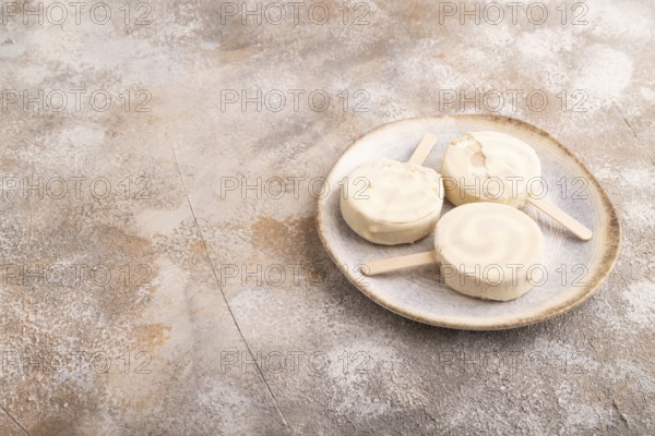 ?hocolate Ice cream in white glaze, on brown concrete background, side view, copy space, minimalism