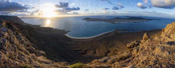 View of steep cliffs to sea and the island of La Graciosa, Mirador del Porrito viewpoint at sunset,