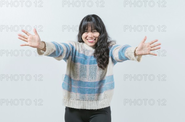 Friendly asian girl welcoming with open arms isolated. Beautiful asian woman welcoming you with