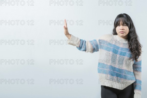Asian girl making rejection gesture with palm of hand isolated. Displeased asian woman rejecting