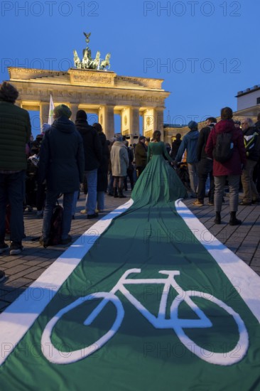 Athena Macke (costume designer) wears a dress with a long train in the shape of a bike path (bike