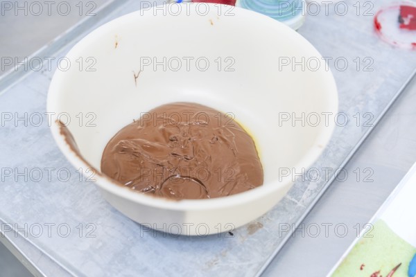A white bowl of melted chocolate on a preparation table, Christmas baking, Haselstaller Hof,