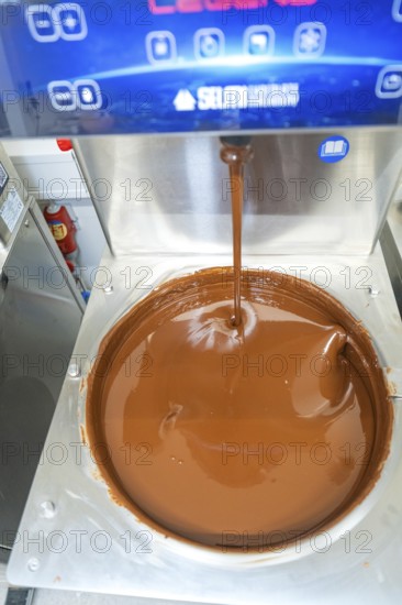 Liquid chocolate is poured into a large container in a machine, Weihnachtsbacken, Haselstaller Hof,
