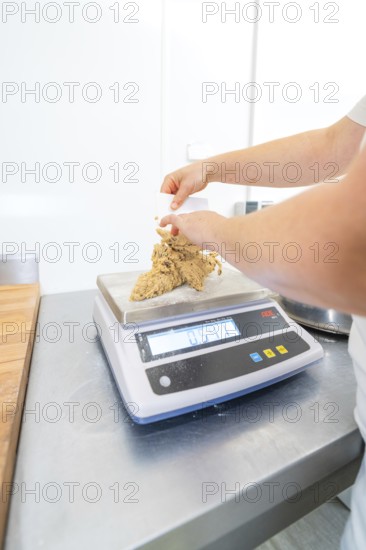 Person molding dough on a kitchen scale in a bright kitchen, Christmas baking, Haselstaller Hof,