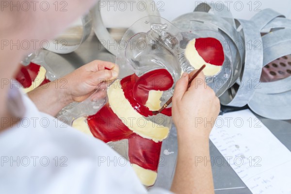 A person paints details in a chocolate Santa Claus mold, Christmas baking, Haselstaller Hof,