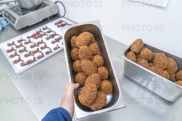 Various rectangular metal containers full of brown chocolate chocolates in a kitchen, Christmas