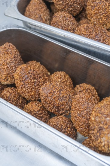 Brown chocolate chocolates with ground hazelnuts served in a metal container, Christmas baking,