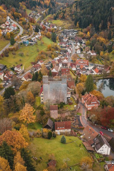 A medieval village surrounds a castle, all bathed in rich autumn colors, Berneck Castle,