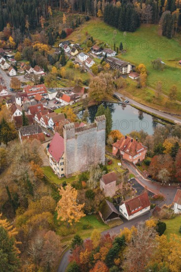 A castle next to a river in the middle of an autumn-colored village, Berneck Castle, Altentsteig,