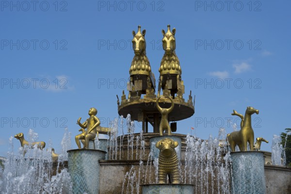 Golden horses and human figures as part of an elaborate fountain with sparkling water, Colchis