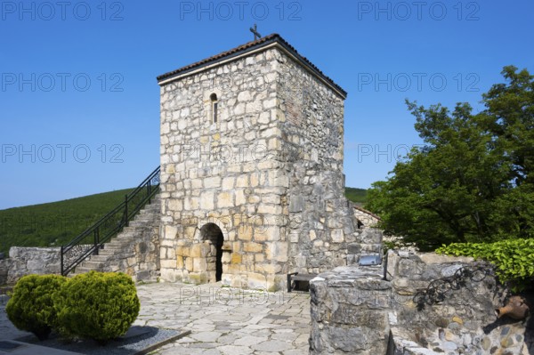 Historic stone tower with small garden and side stairs in a quiet area, Motsameta monastery, near