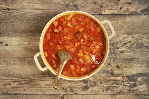 Top view of a hearty beef stew in a large pot, filled with tender beef chunks, colorful vegetables,