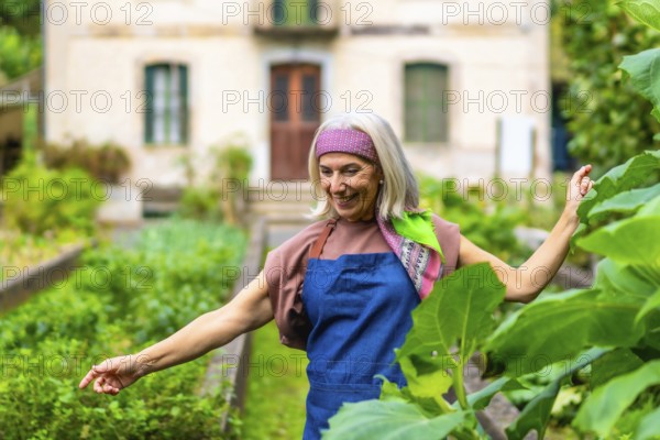 Senior woman with gray hair and colorful headband smiling while standing in her flourishing home