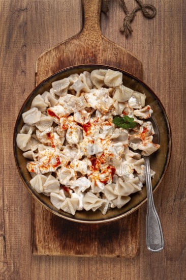 The dish features a generous serving of Turkish dumplings topped with velvety yogurt and a drizzle