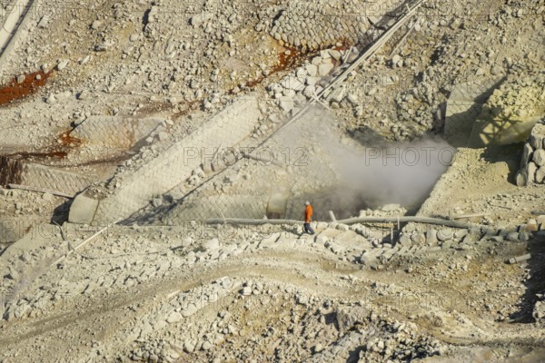 Workers among steaming fumaroles in the Owakudani geothermal area at Komagatake volcano, Hakone,