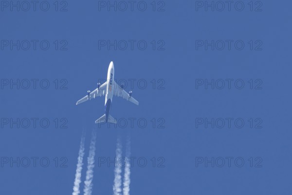 Boeing 747 jumbo jet cargo aircraft of Atlas air airlines flying in a blue sky with contrails or