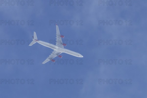 Airbus A340 jet cargo aircraft of European Cargo airlines flying in a blue sky, England, United