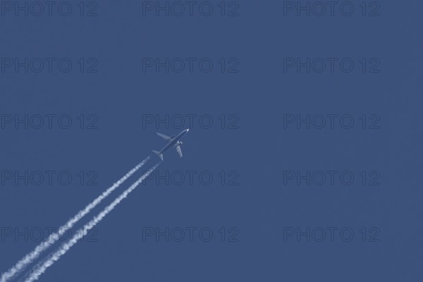 Boeing 737 jet passenger aircraft of Ryanair airlines flying in a blue sky with contrails or vapour