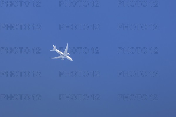 Boeing 787-8 Dreamliner jet passenger aircraft of Qatar airways airlines flying in a blue sky,