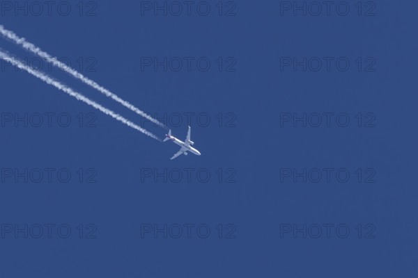 Airbus jet passenger aircraft of Eurowings airlines flying in a blue sky with contrails or vapour
