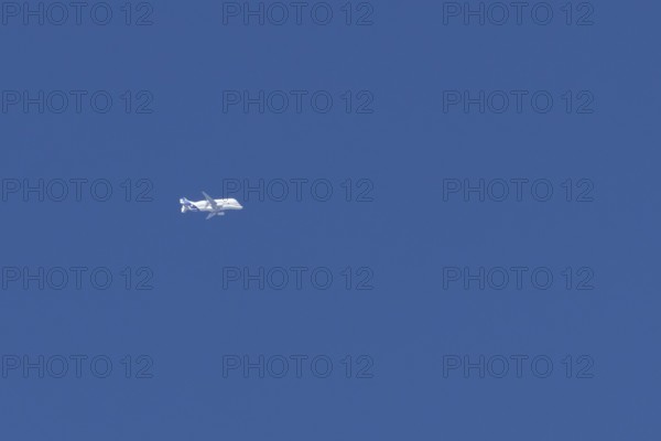 Airbus A330-743L Beluga XL cargo jet aircraft flying in a blue sky with white clouds, England,