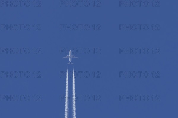 Airbus jet passenger aircraft of Kuwait airways flying in a blue sky with contrails or vapour