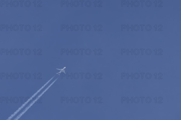 Airbus jet passenger aircraft of Eurowings airlines flying in a blue sky with contrails or vapour